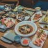 different foods in plates on brown wooden dining table